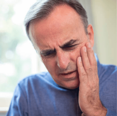 Middle aged man holding jaw because of pain