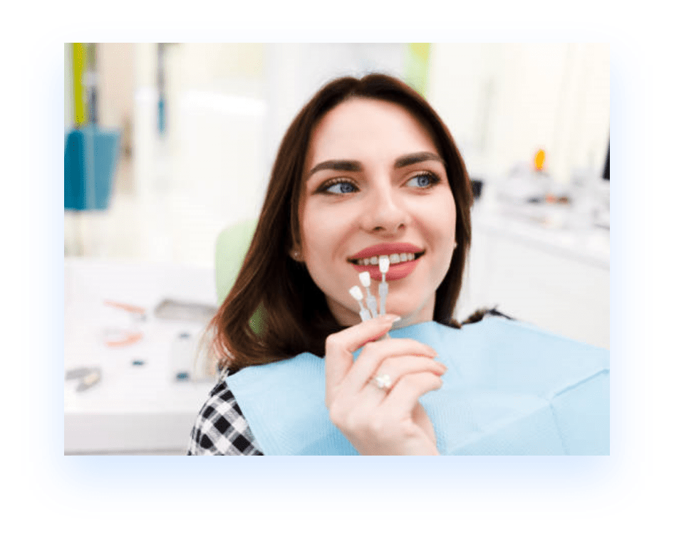 Woman at dentist office matching dental veneers to her natural teeth