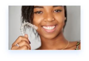 Young black woman holding Invisalign retainer