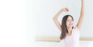 woman stretching and waking up happy
